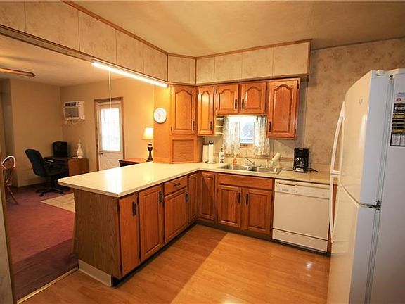 Plenty of Gorgeous Wood Cabinets in Spacious 12x11 Eat-in Kitchen featuring a Breakfast Counter in Dining Room & Nice Pergo Floo