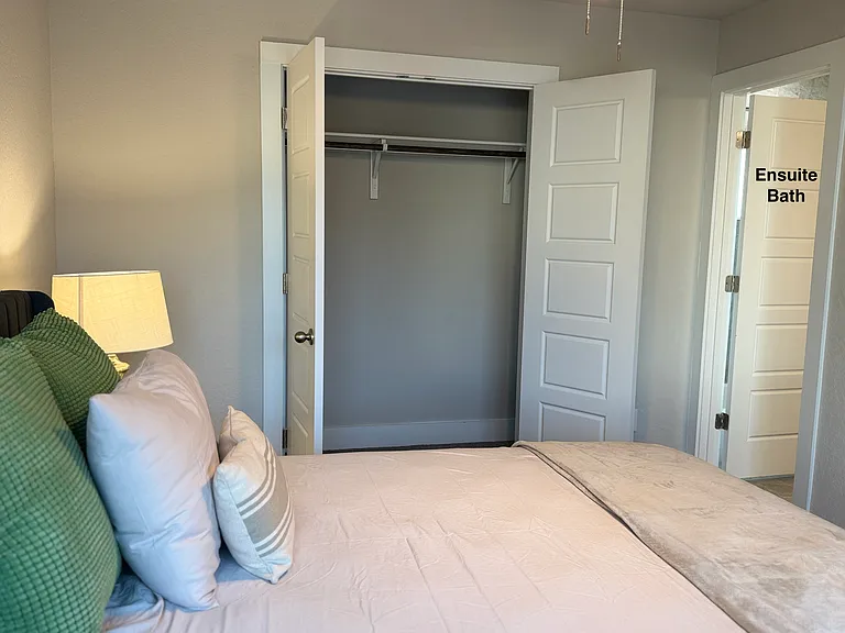 Bedroom 2 with queen bed, desk, private ensuite bathroom and spacious closet