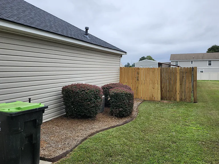 Close-up view of the right side of the property; well maintained front & entrance via fence (wood) to backyard.