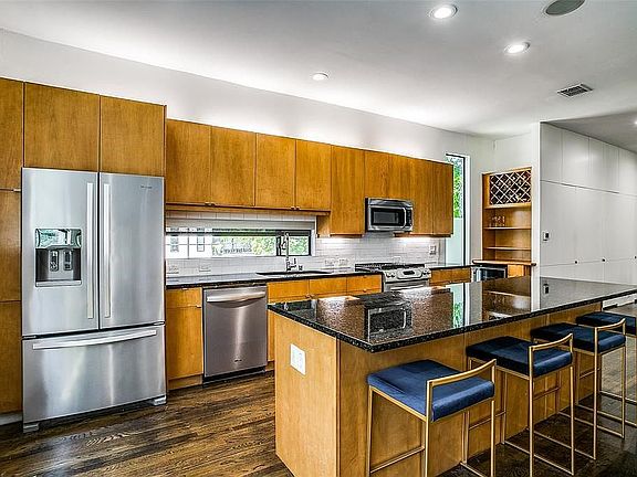 Bright spacious kitchen with large island, wine fridge, and stainless steel appliances