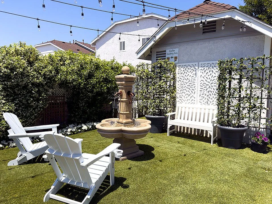 Outdoor seating and fountain in resident garden area.