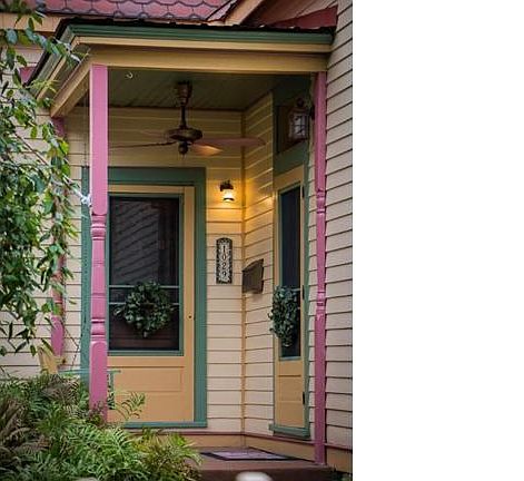 Antique industrial fan compliments the porch where you can enter the home through 2 original doors.