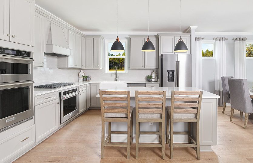 The elegant pendant lighting complements the spacious gourmet Kitchen.