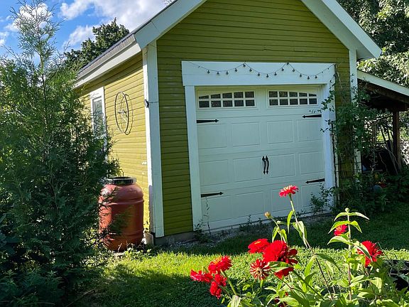 Barn in the backyard near flowers and fruit trees with outdoor seating