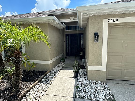 Experience Florida living being greeted by palms and a landscaped front entry