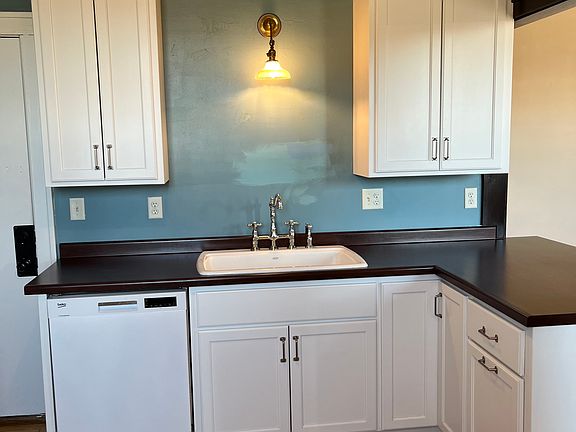 Kitchen sink view with kitchen front door.