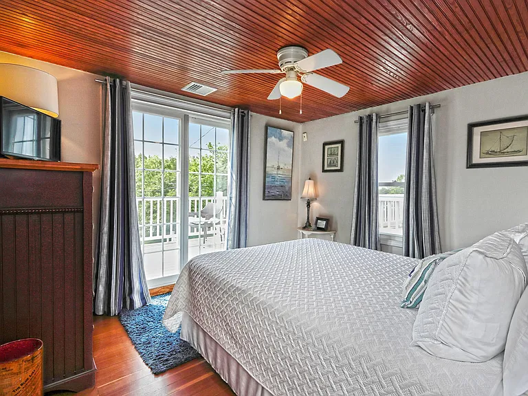 Primary bedroom with queen size bed. Sliders lead to upper balcony with water views.