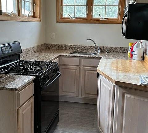 Kitchen with dishwasher, microwave, refrigerator and granite tops