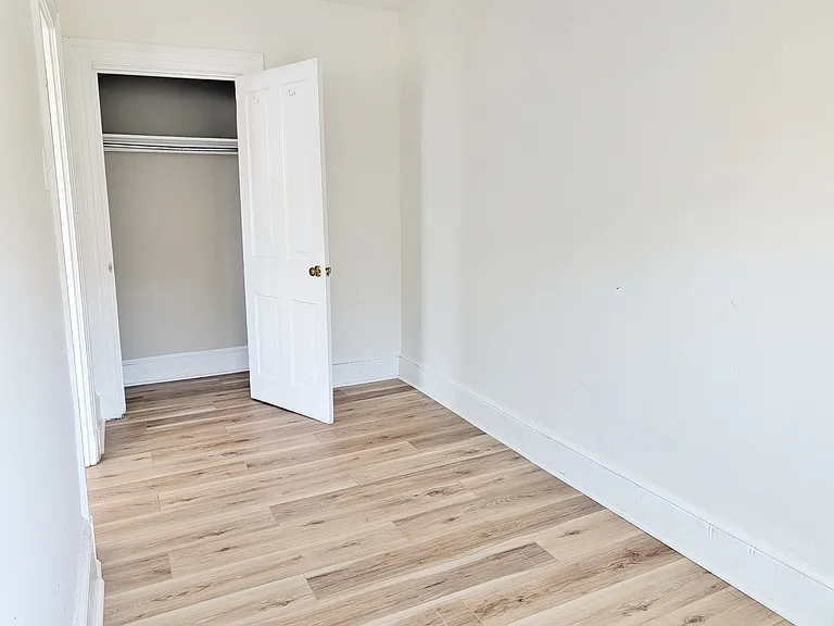 Bedroom w/ Closet and Luxury Vinyl Plank Flooring