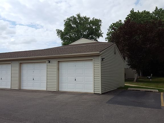 Sidewalk to building behind these garages