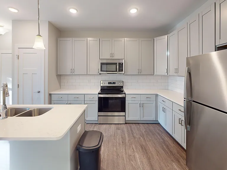 The Elm floor plan features custom cabinetry, a pantry, a kitchen island with double sinks, and stainless steel appliances. The Elm floor plan features custom cabinetry, a pantry, a kitchen island with double sinks, and stainless steel appliances.