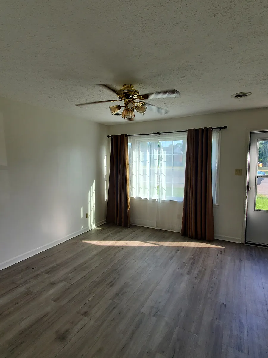 Living room with beautiful laminated flooring and drapes - 1103 Lola Ave #3