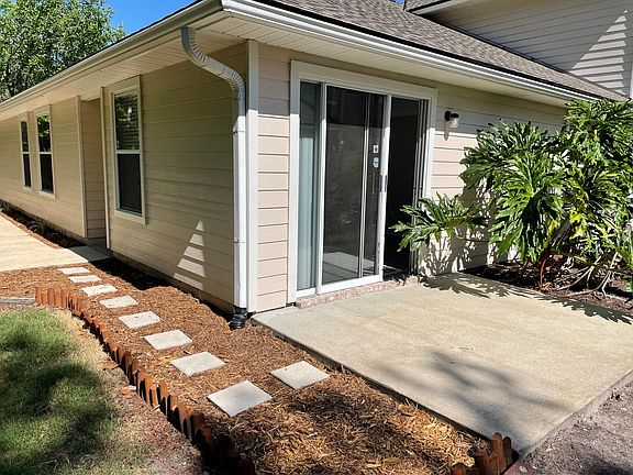 Outdoor shaded patio with walkway beside quiet natural preserve