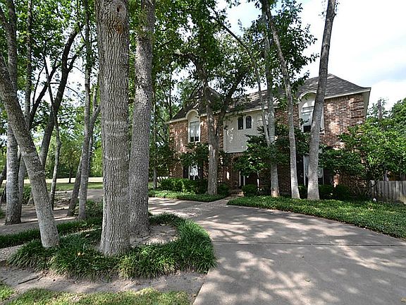 Front view of home showing circular drive and siding to the walk-in trails of Hersey Park in the heart of the Energy Corridor.