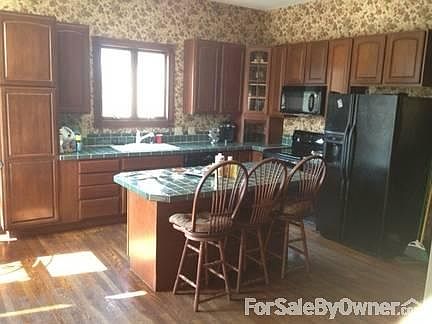 Kitchen
						:
						Large kitchen with tiled countertops and wood floors. All appliances stay