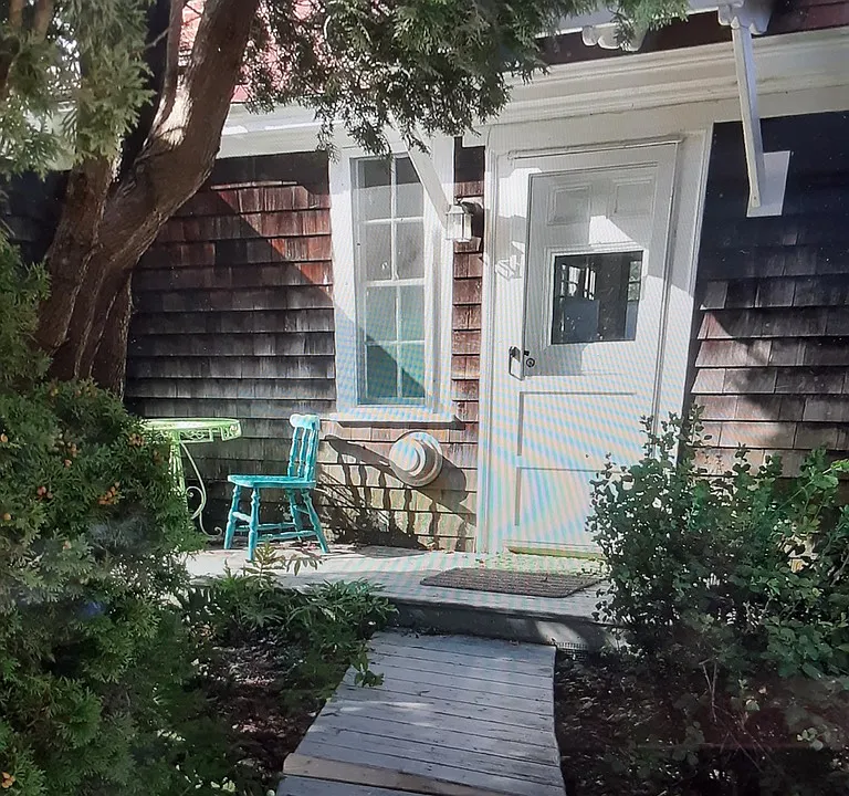 Arborvitae and perennial plantings surround the doorway for 25 B Waterway Rd.