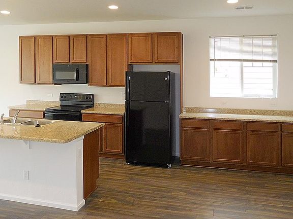 Spacious Kitchen area with appliances, hardwood floor and island at a perfect pivot point for kitchen prep.