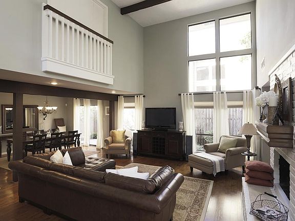 Spectacular FAMILY ROOM-20x17-features 2 story wood beamed ceiling with abundant windows providing plenty of natural light, recessed lighting, gleaming hardwoods, and double sided gas fireplace with brick surround.