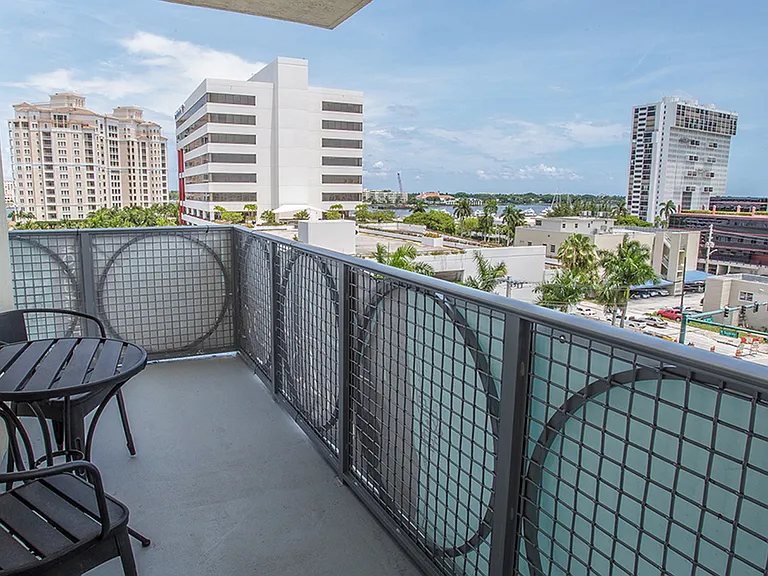 Private luxury apartment balcony with outdoor seating and city skyline views