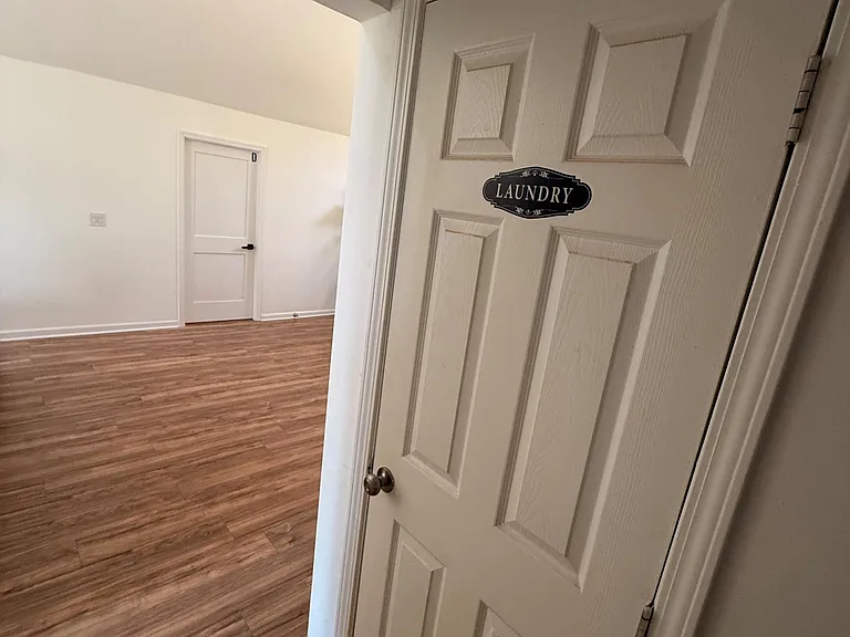 Convenient interior laundry area off the main living space, with easy-access doors and durable hard-surface flooring.