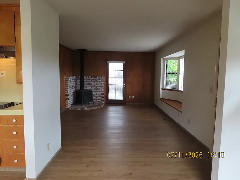 Living room from Dining area with woodstove and window seat bay window