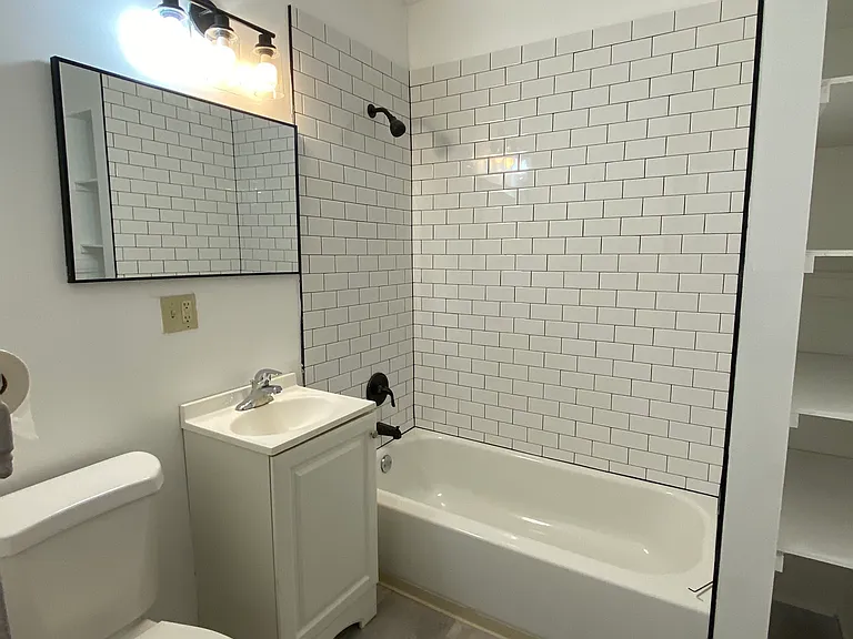 A modern bathroom with sharp subway tile and black trim (sink faucet will be replaced)
