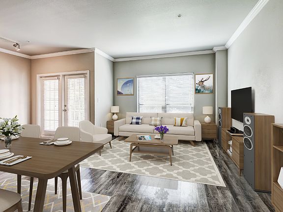 Living room with large windows, wood-style flooring, entry to private patio/balcony