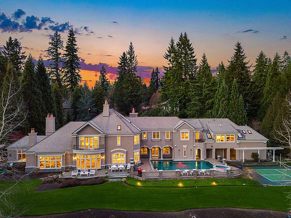 Lush grounds unfold to complement a pristine northwest exterior with manicured hedges, stone pathways, and patio spaces that ignite conversations--all at the water's edge.