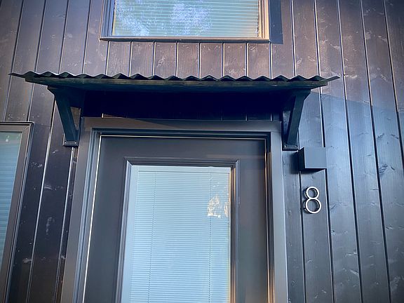 Escaperoo entry door with an awning and keypad entry.