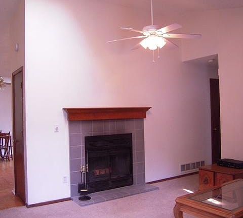 Living Room with fireplace, ceiling fan & skylight.