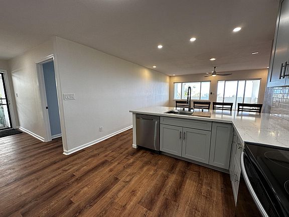 Panoramic ocean view from kitchen with open floor plan for living/dining area and covered lanai.