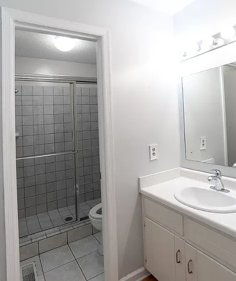 Ensuite bath for primary bedroom with tiled shower and large vanity