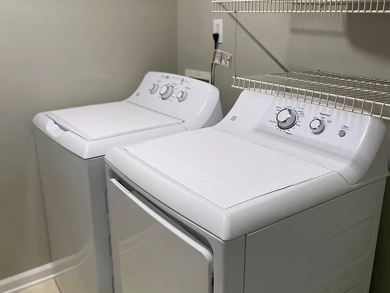 Laundry room with new washer and dryer. laundry room has door to garage