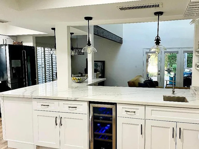 Kitchen, wine fridge, bar sink looking over living room. (note the windows in back left are different now, see dining room pic for update after replacement)