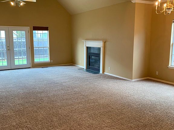 Living room with gas fireplace, french doors to the back yard, and open to the dining room