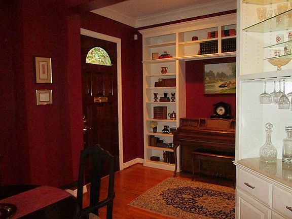Inside the front door to your right is the dining room, to the left a wall of built-in storage, book