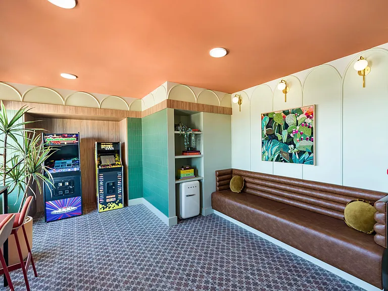 A retro-inspired arcade lounge at Modera St. Paul, featuring classic games, cozy seating, and playful design details in the heart of Dallas.
