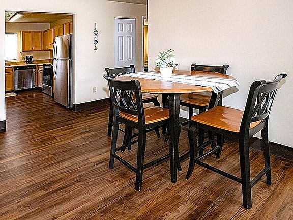 Charming dining area with a cozy wooden table, complemented by an inviting open kitchen featuring modern appliances.