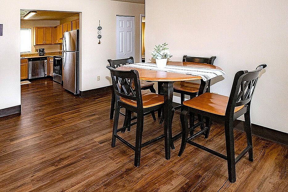 Charming dining area with a cozy wooden table, complemented by an inviting open kitchen featuring modern appliances.