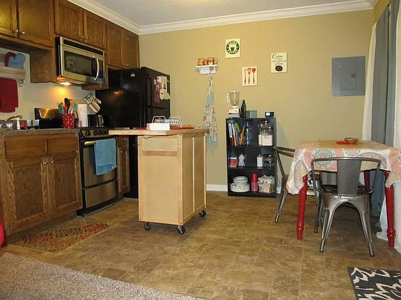Kitchen with range, microwave, full size fridge.