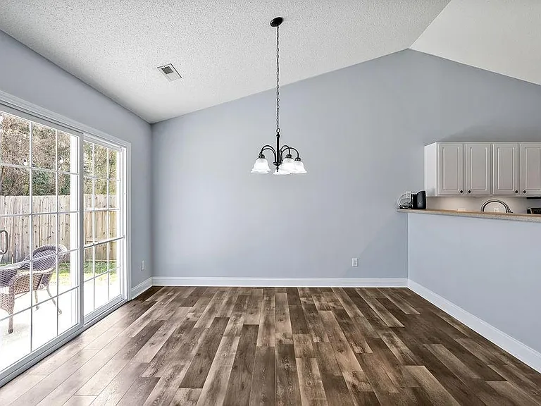 Dining room with sliding door to the patio to the left and kitchen to the right