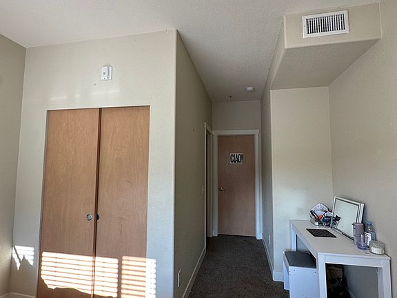 a spacious entryway into the bedroom with a bathroom along the hallway