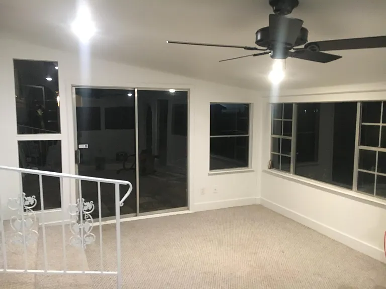 Sun room with ceiling fan. This room also has A/C like the rest of the house. Floor is carpeted. Apologies, this photo was taken at night.