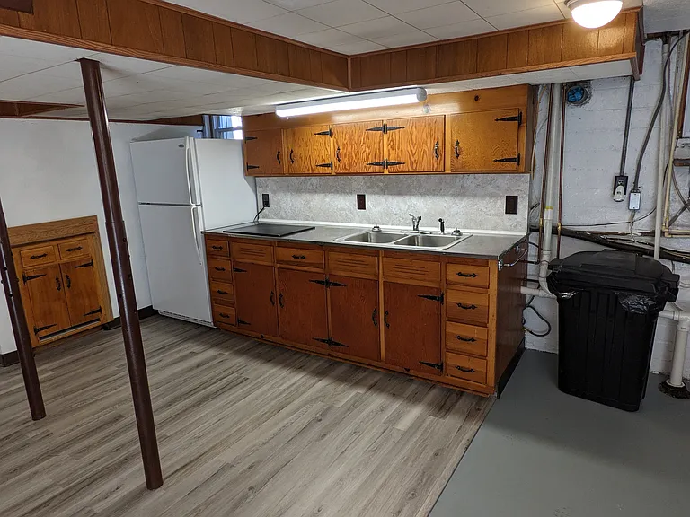 The basement includes an open area with kitchenette and second refrigerator.