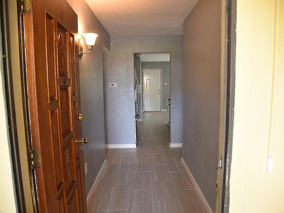 Custom wood carved front door. NEW Porcelain flooring in entry, hall, kitchen, living, dining areas.