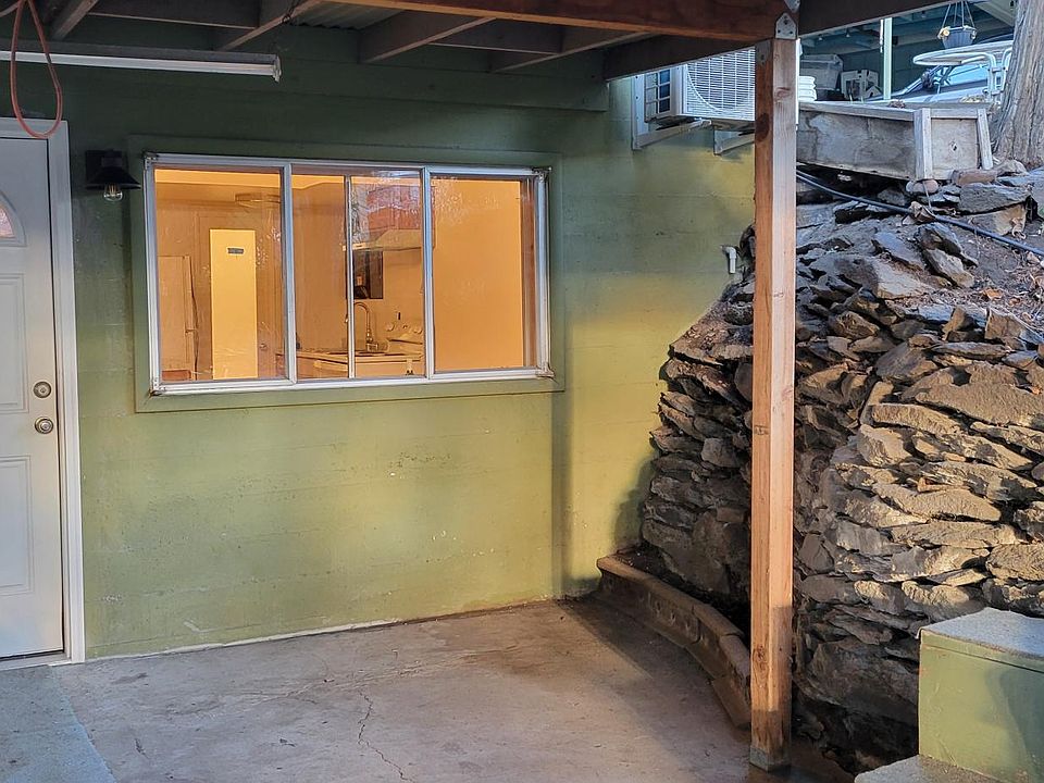 Outside entrance and covered parking for smaller vehicles. Flower garden area on the rock wall, and more.