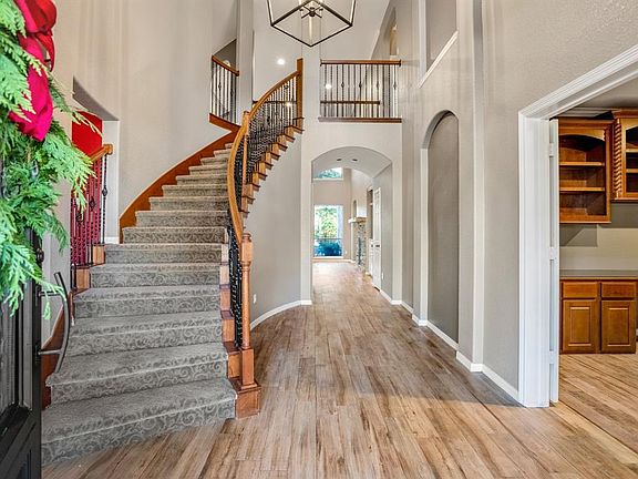 Inviting two story foyer with spiral staircase and gorgeous wood like tile throughout.