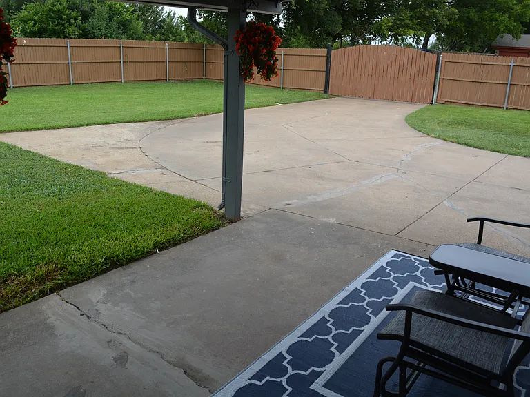 Covered patio area with outdoor furniture and a BBQ grill.