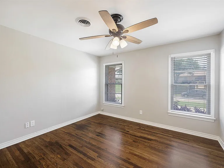 Spare room with hardwood / wood-style flooring and ceiling fan