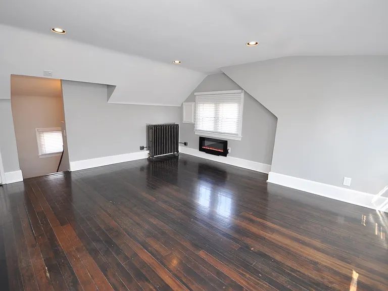 Charming living room with chic electric fireplace, real Douglas Fir hardwood floors, big, bright windows, and dimmable / programmable Philips Hue Smart lighting